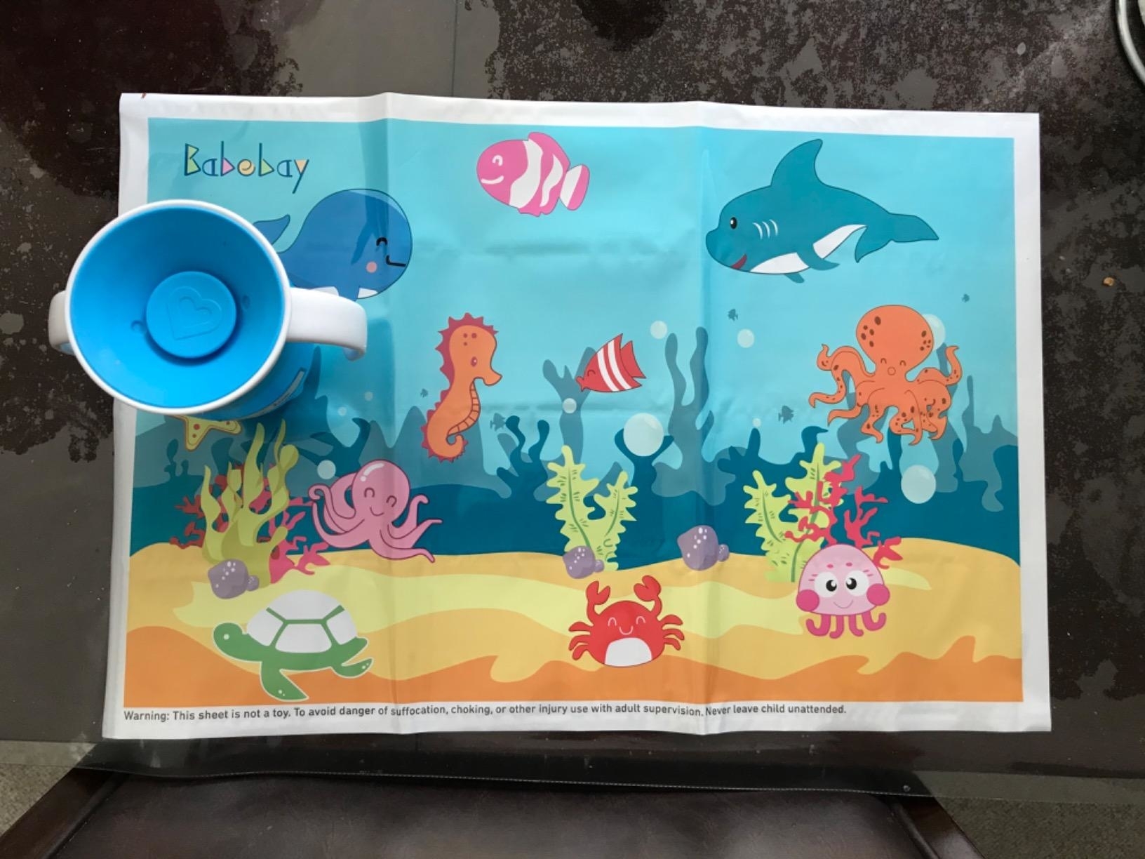 Illustration of various marine creatures and a plastic cup on a children&#x27;s placemat