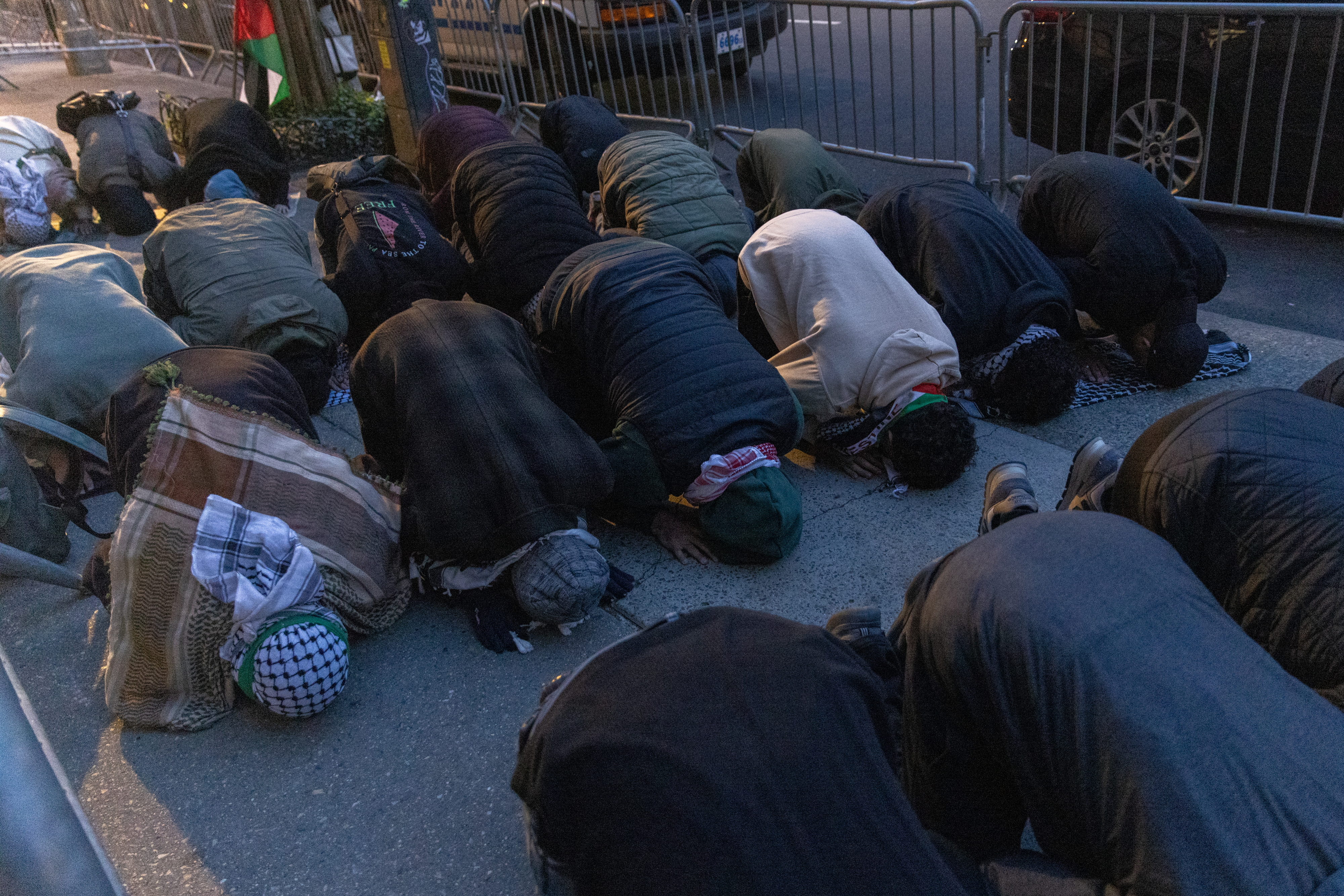 Group of people in prayer outside, kneeling on the ground