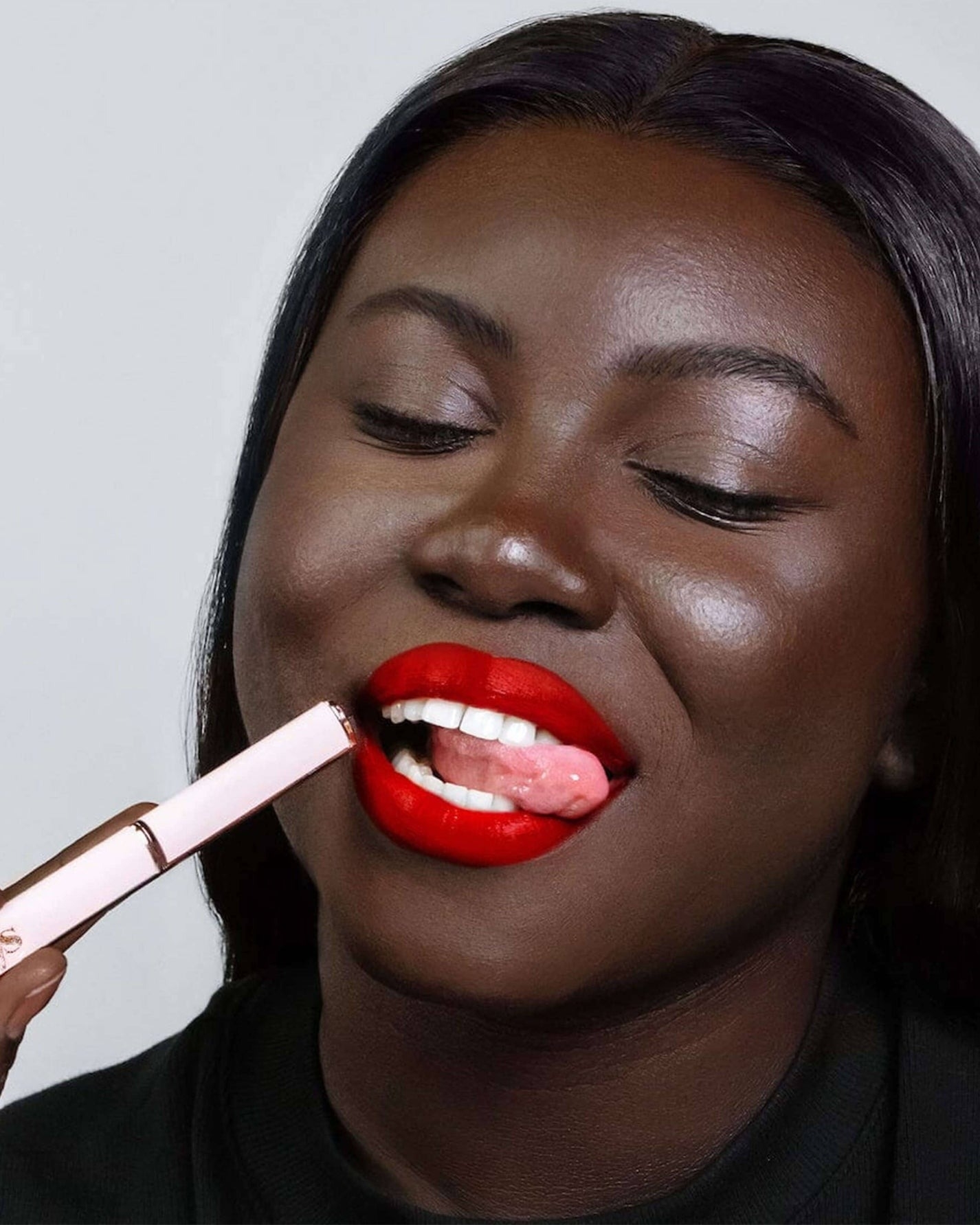 Woman applying bright lipstick, showcasing makeup product for shopping article