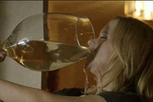 Person drinking from an oversized wine glass
