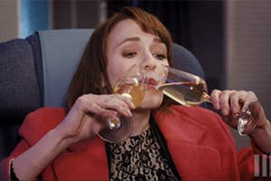 Woman sipping two glasses of wine simultaneously, looking stressed