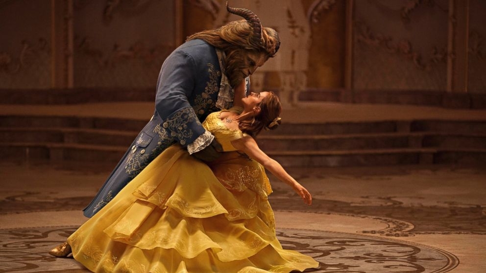 Characters Belle and Beast are dancing, Belle in a yellow gown and Beast in a blue coat
