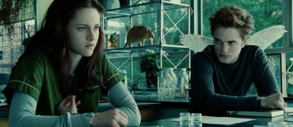 Bella Swan and Edward Cullen sitting at a table in a scene from Twilight