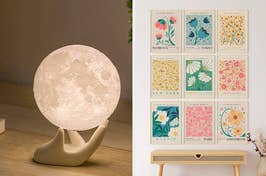 On the left, a moon-shaped lamp on a hand-shaped stand. On the right, art prints of various cities displayed