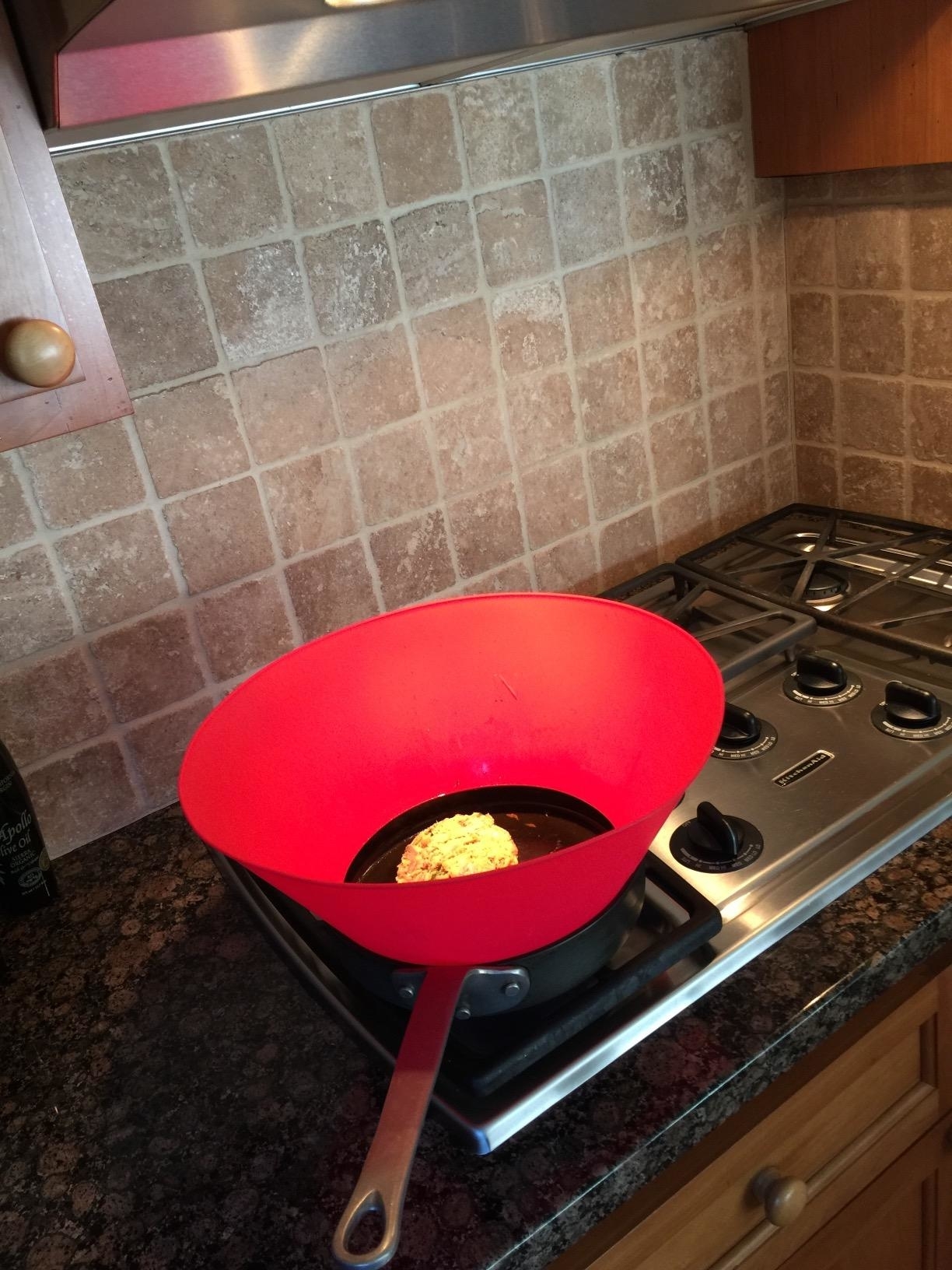 Red skillet on a stove with food cooking, in a kitchen. Ideal for home chefs looking to upgrade their cookware