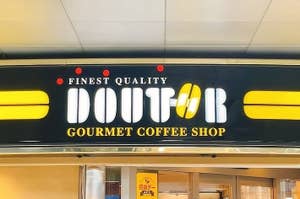 画像は「FINEST QUALITY DOUTOR GOURMET COFFEE SHOP」と書かれたコーヒーショップの看板です。