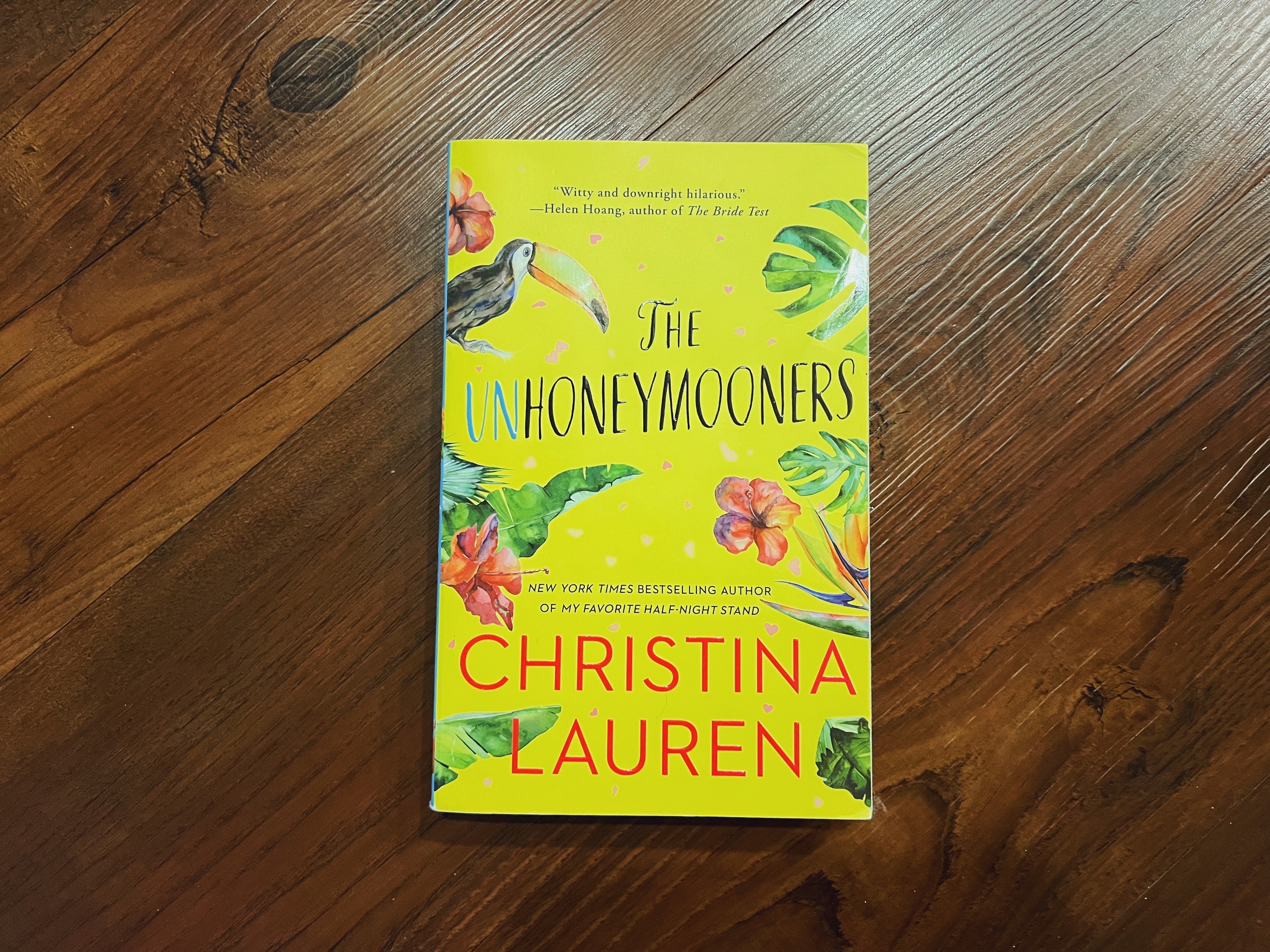 Book cover of &quot;The Unhoneymooners&quot; by Christina Lauren with a tropical floral design