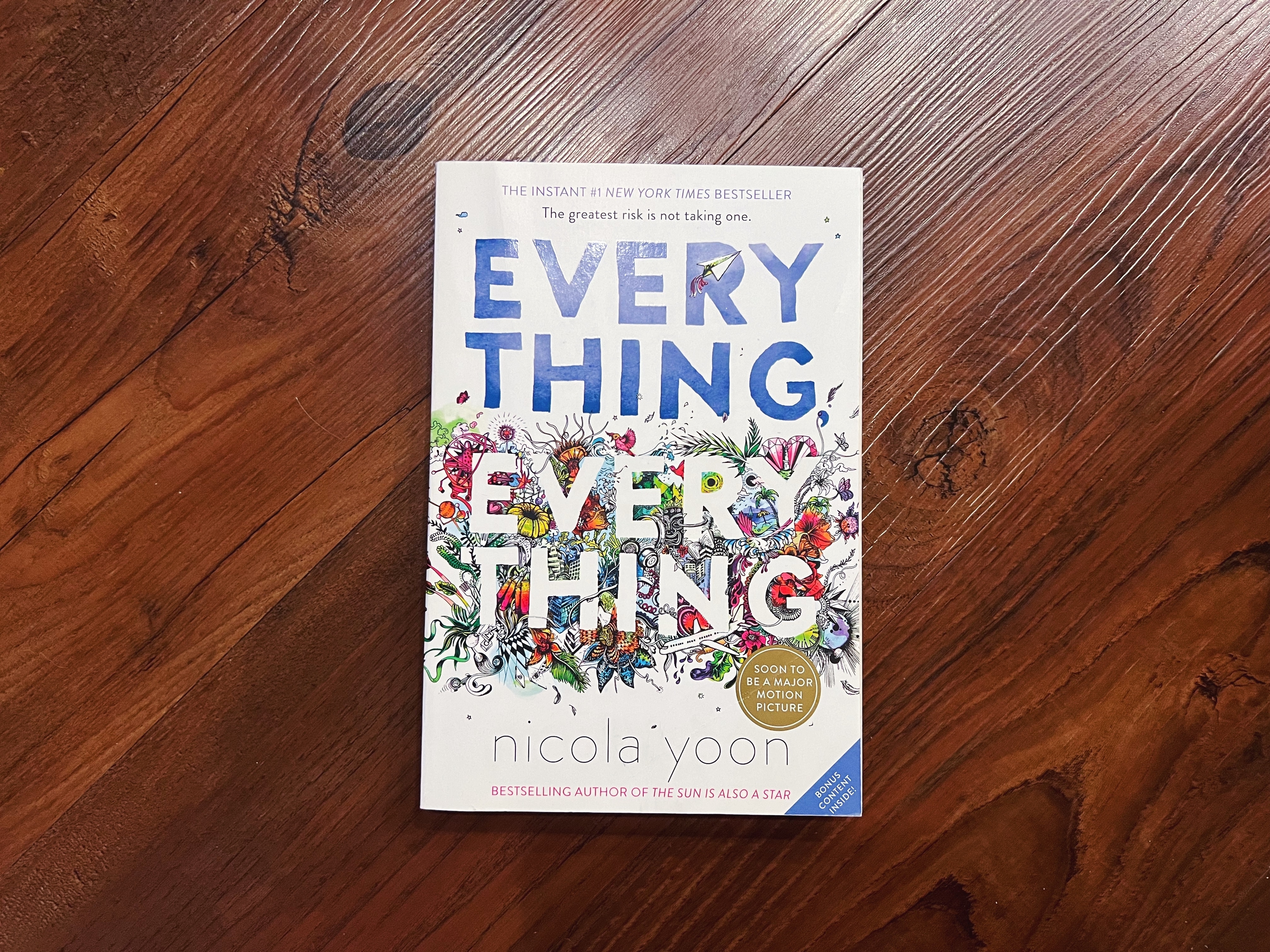 The photo shows the book &#x27;Everything, Everything&#x27; by Nicola Yoon on a wooden surface