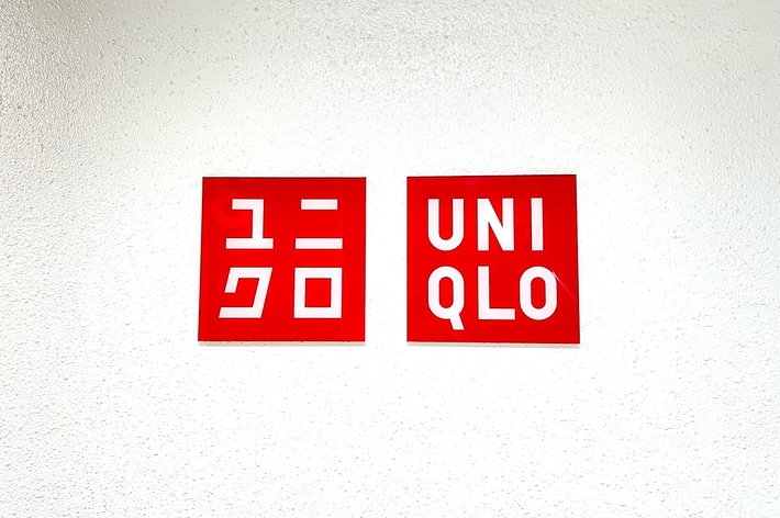 Two signs on a wall: one with Japanese characters and the other reading "UNIQLO."