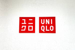 Two signs on a wall: one with Japanese characters and the other reading "UNIQLO."