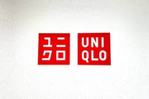 Two Uniqlo brand logos in Japanese and English on a wall