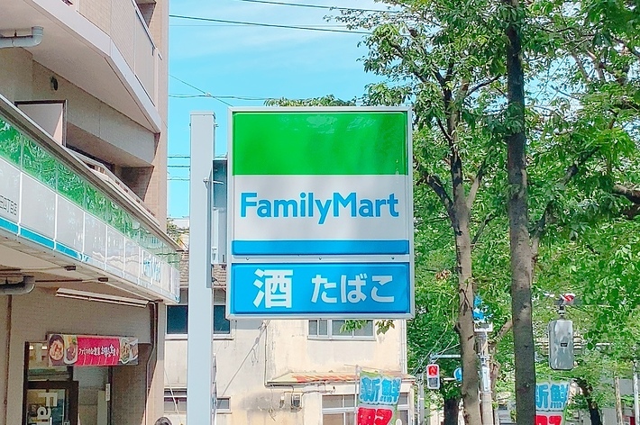 ファミリーマートの看板があり、周囲には木々が見えます。