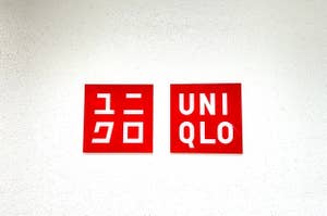 Two signs with the logos "GU" and "UNIQLO" side by side on a wall