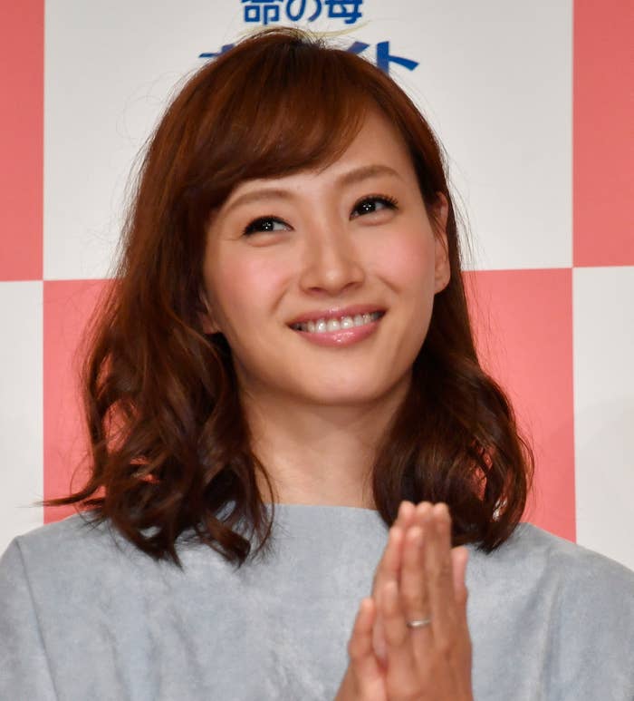 女性が手を合わせて微笑んでいるポートレート。