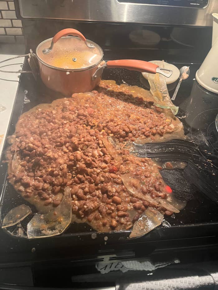 Pot and cooked food spilled over stove top