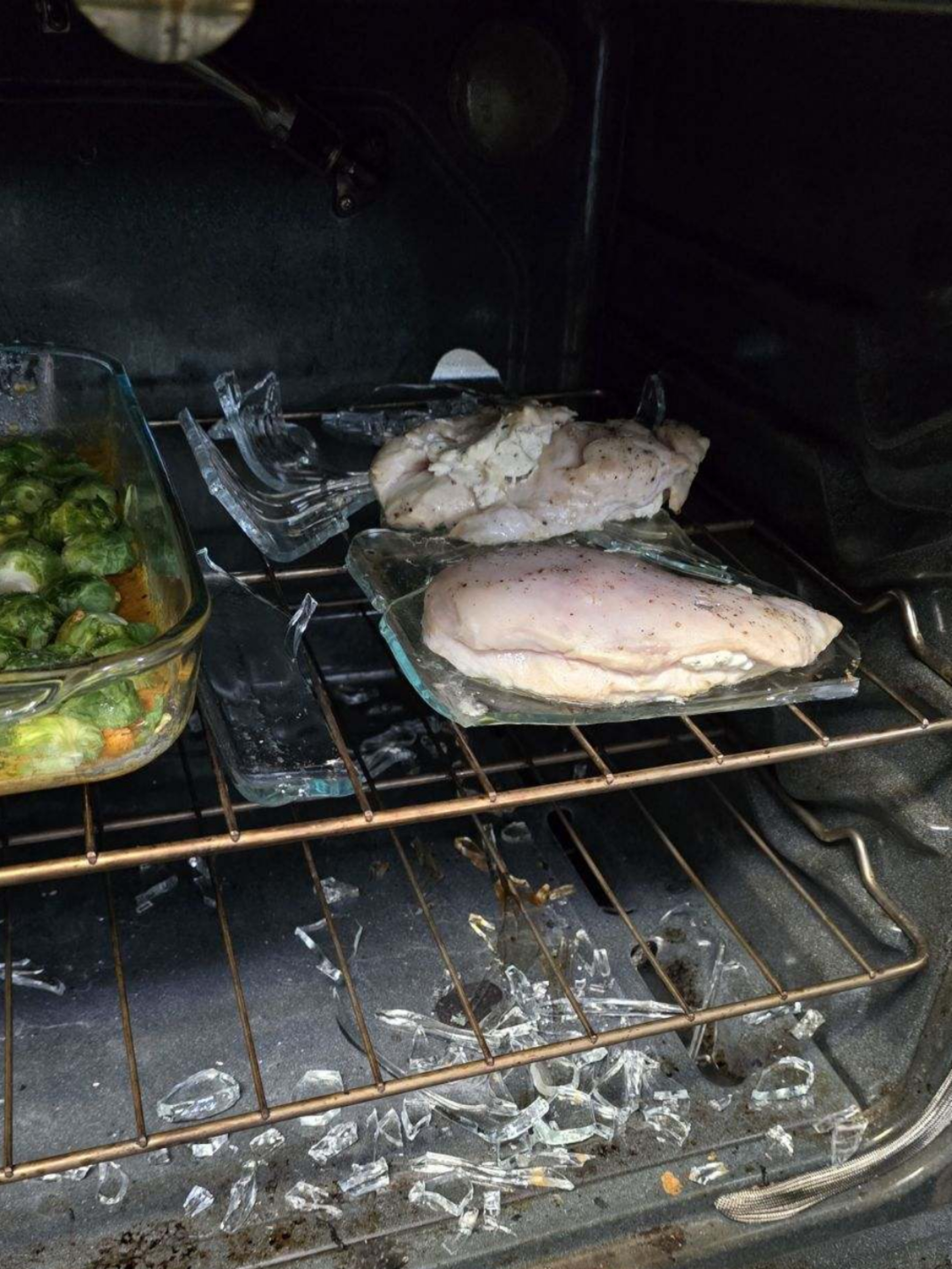Chicken and vegetables in an oven with broken glass dish