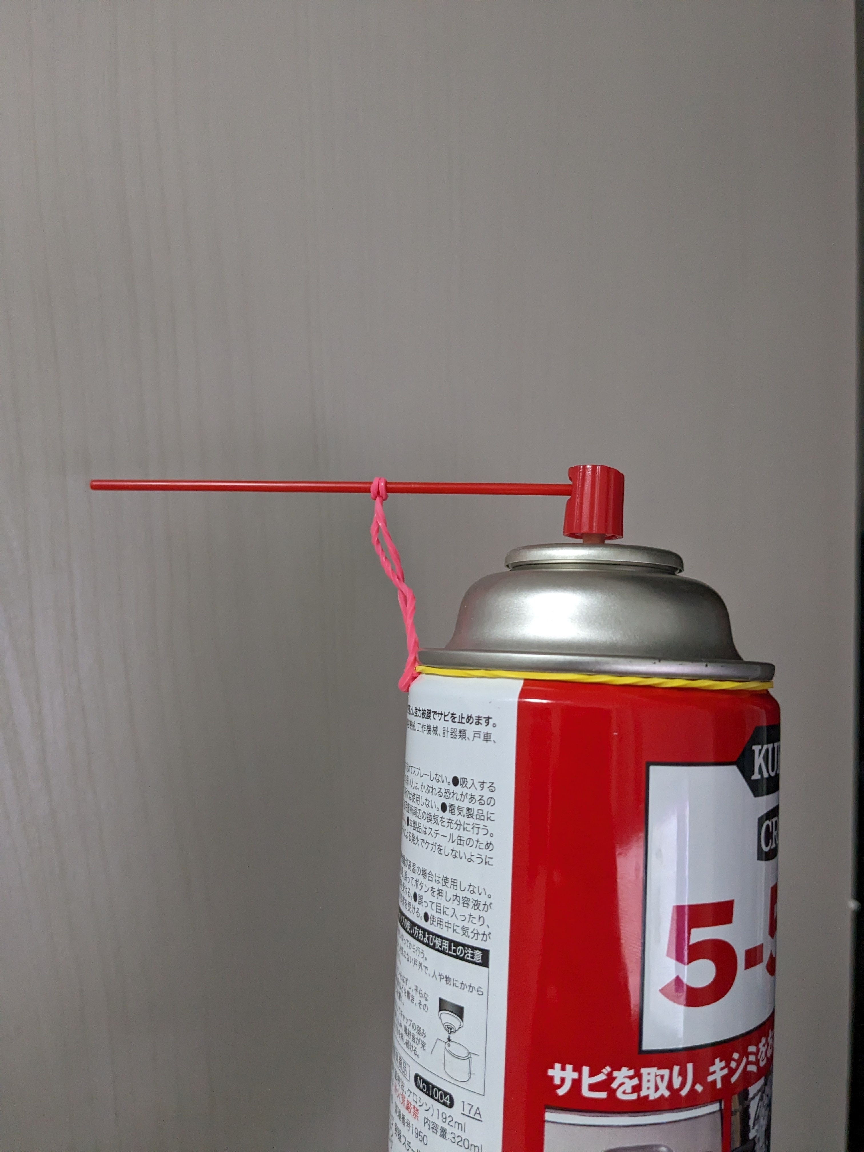 スプレー缶に紐が結び付けられている。