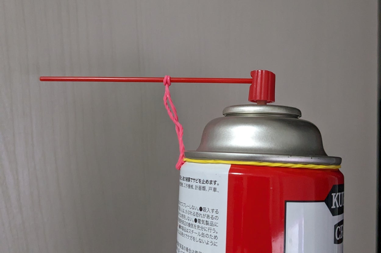 スプレー缶に紐が結び付けられている。