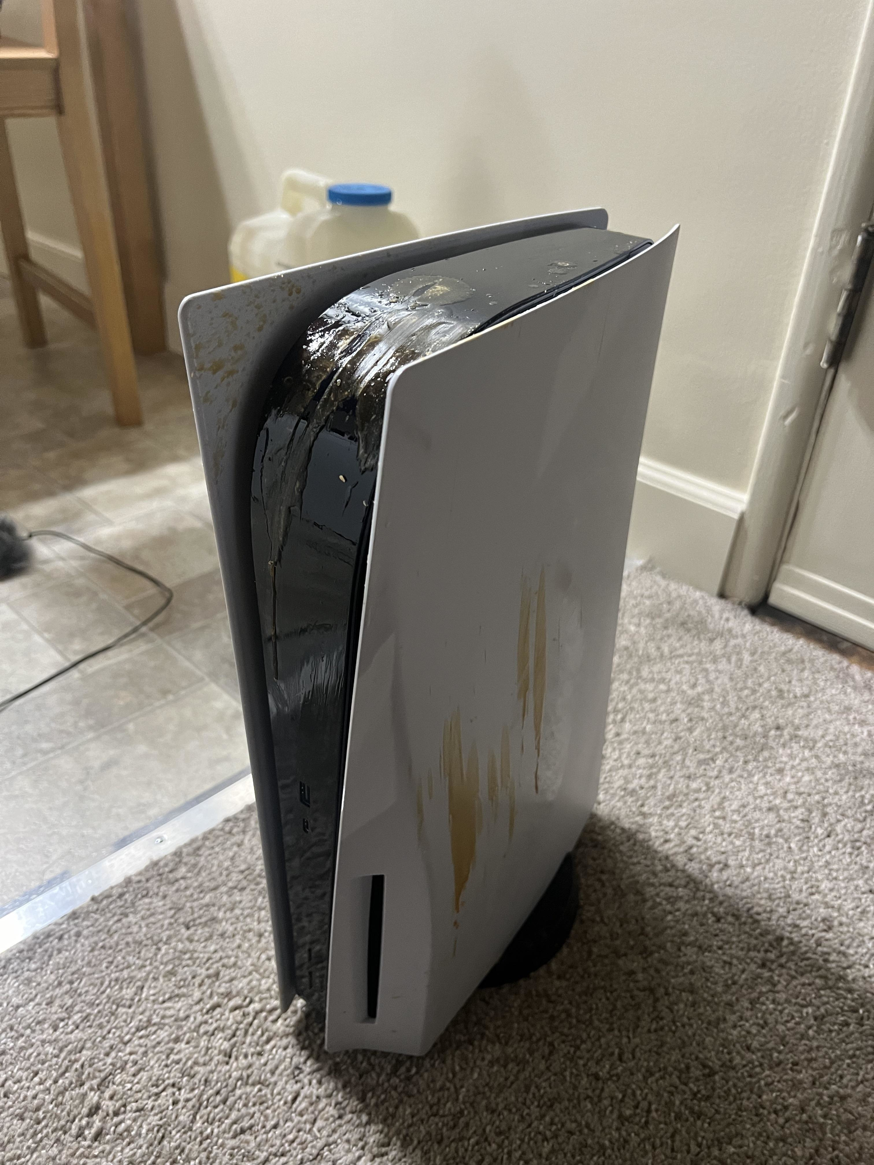 Damaged gaming console with stains on carpeted floor