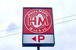 Sign for Hoto Motto, a Japanese bento takeout chain, with logo and Japanese text, against the sky