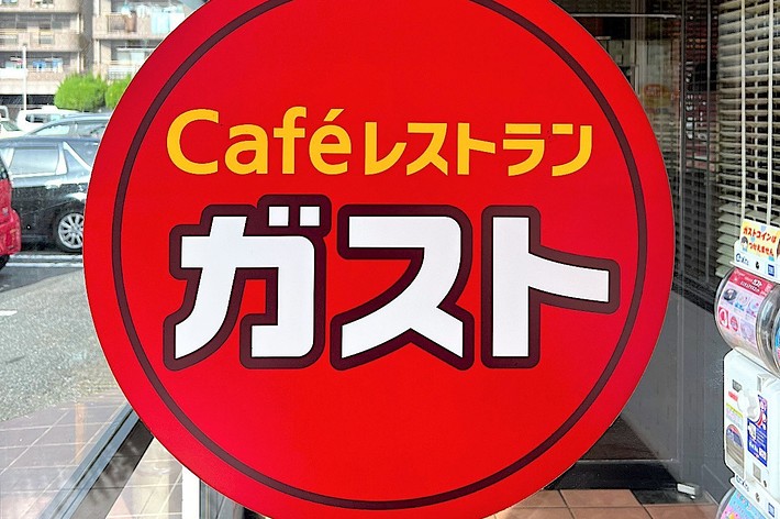 Café sign in Japanese and English, with stylized text and a graphic of a drink