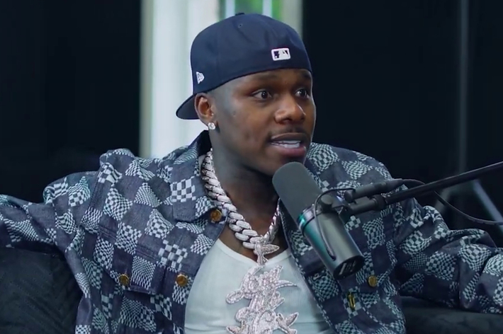 DaBaby wearing a patterned jacket in a podcast studio with a microphone