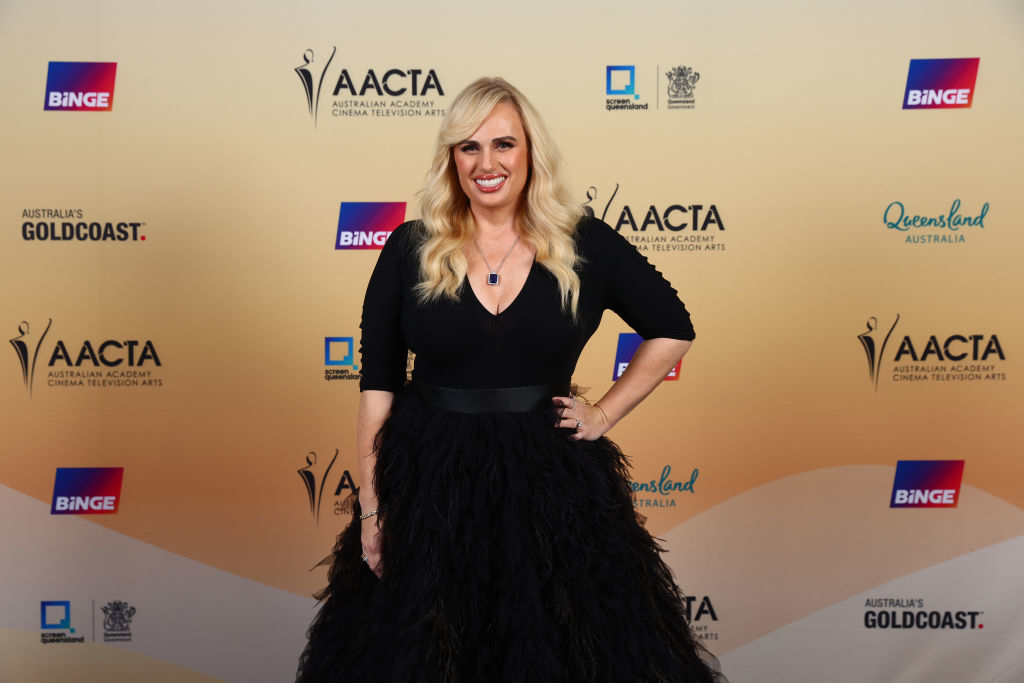 Rebel in long-sleeved top and feathered skirt posing at the AACTA event
