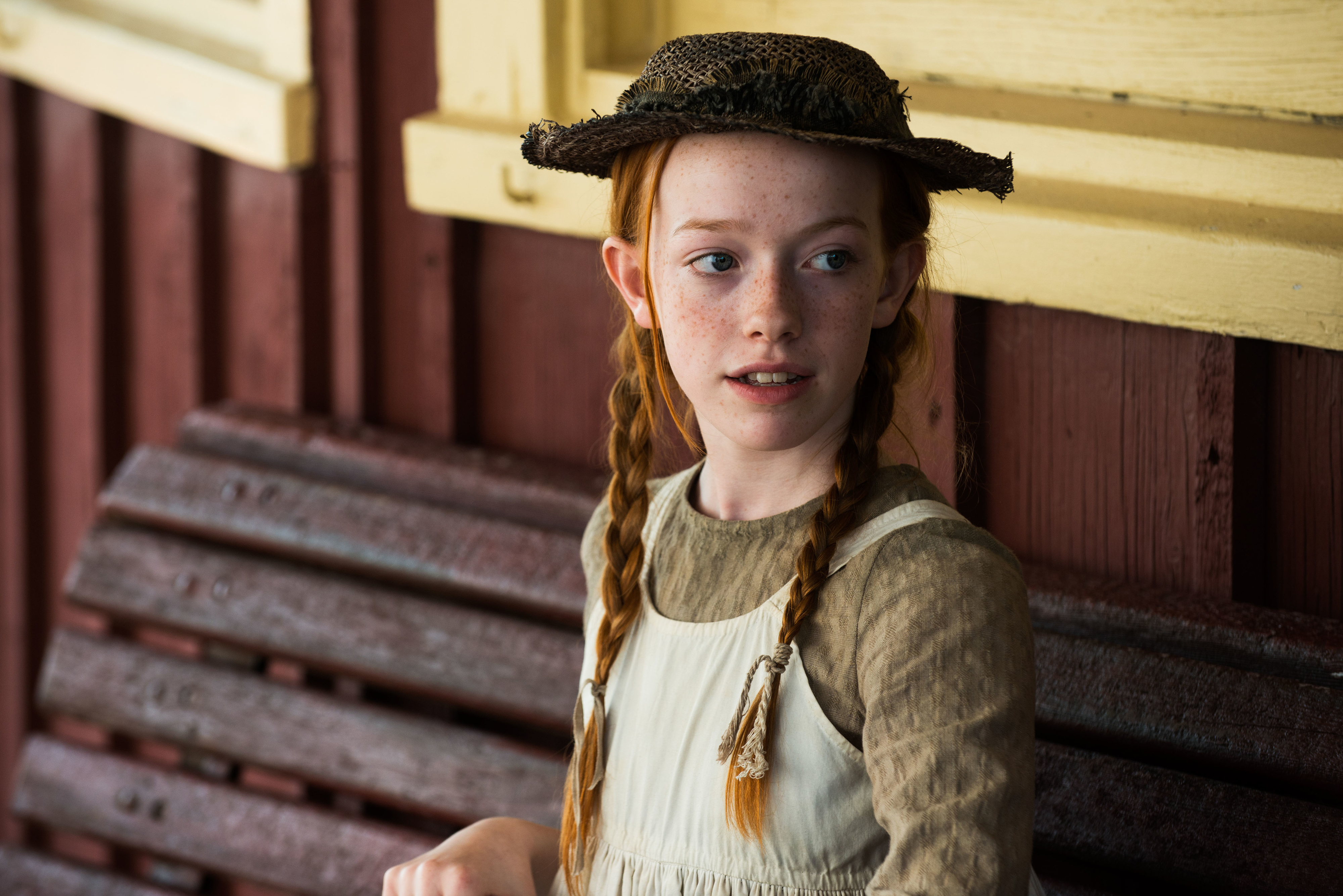 Character Anne from &#x27;Anne of Green Gables&#x27; in period clothing with braids and a straw hat