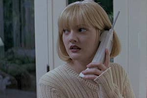Drew Barrymore as Casey Becker on the phone looking scared in the movie "Scream". She's wearing a beige sweater