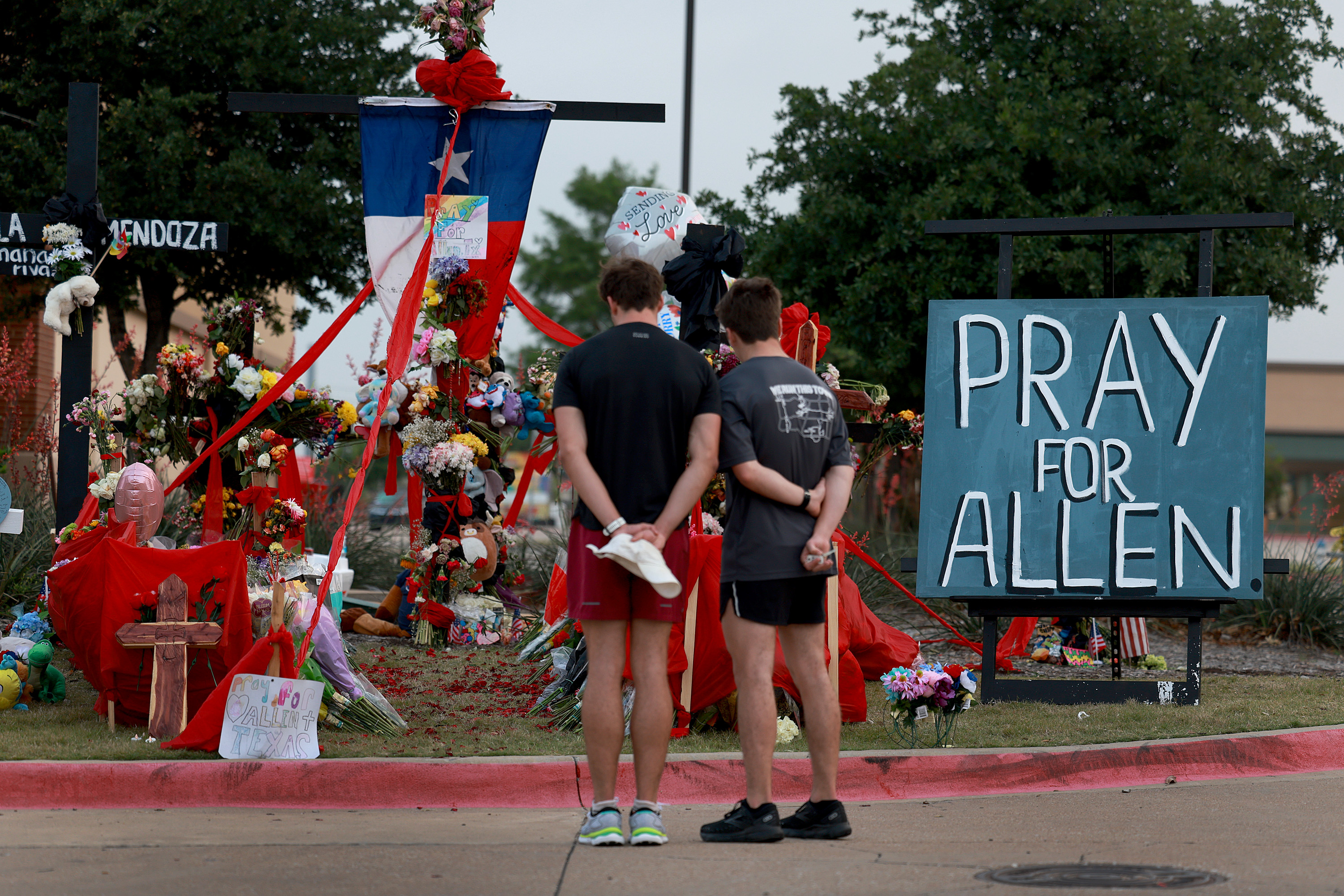 People at a memorial site for victims of the Allen mall shooting