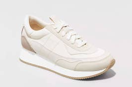 A single white sneaker with a minimalist design displayed against a light background