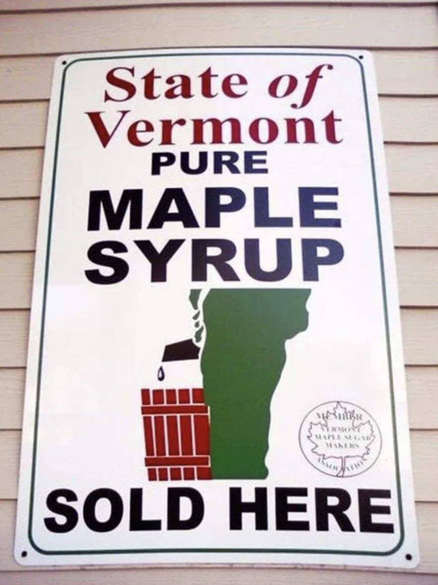 A sign reads &quot;State of Vermont Pure Maple Syrup Sold Here&quot; with a graphic of a syrup jug