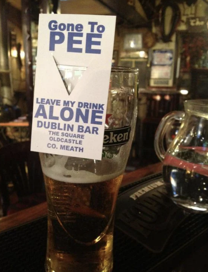 Sign on a glass of beer reads &quot;Gone to PEE - Leave my drink alone&quot; at The Square Castle bar
