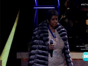 Aretha franklin taking off a fur coat to reveal a sequin dress