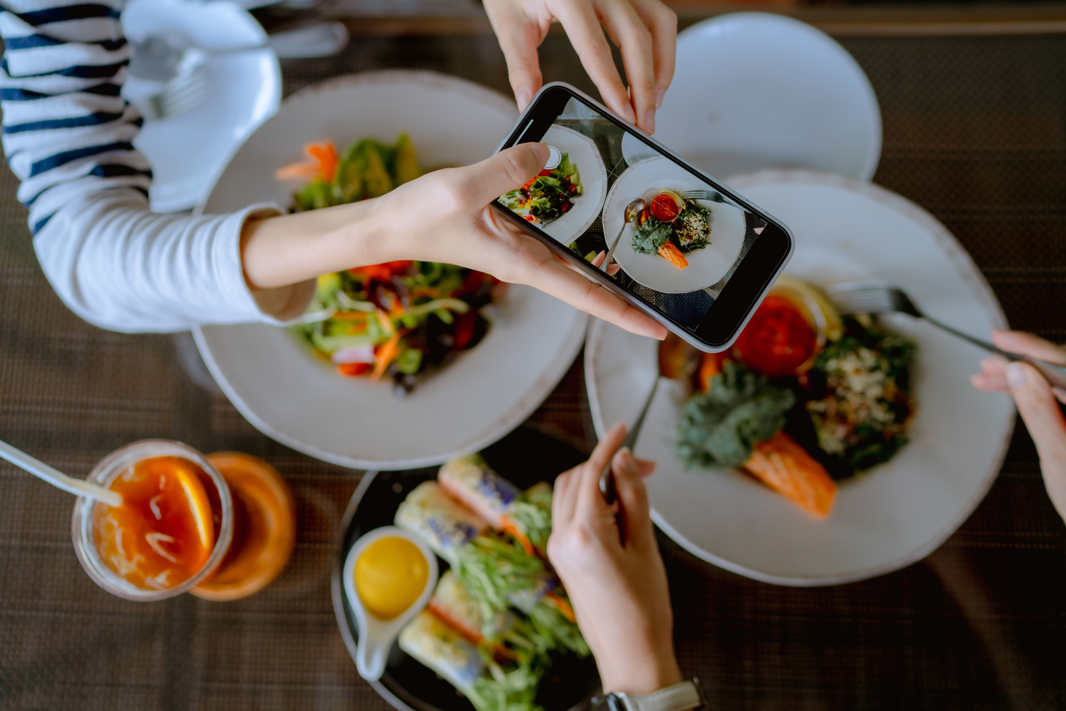 Person taking a photo of a plate of food with their smartphone