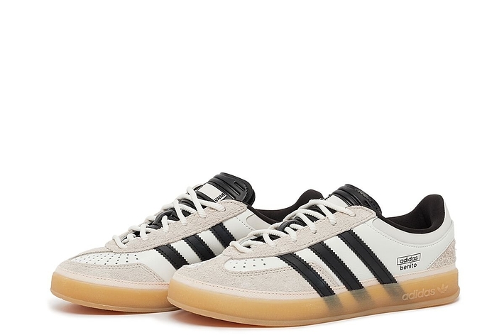 A pair of Adidas sneakers with iconic stripes, lace-up fronts, and textured soles