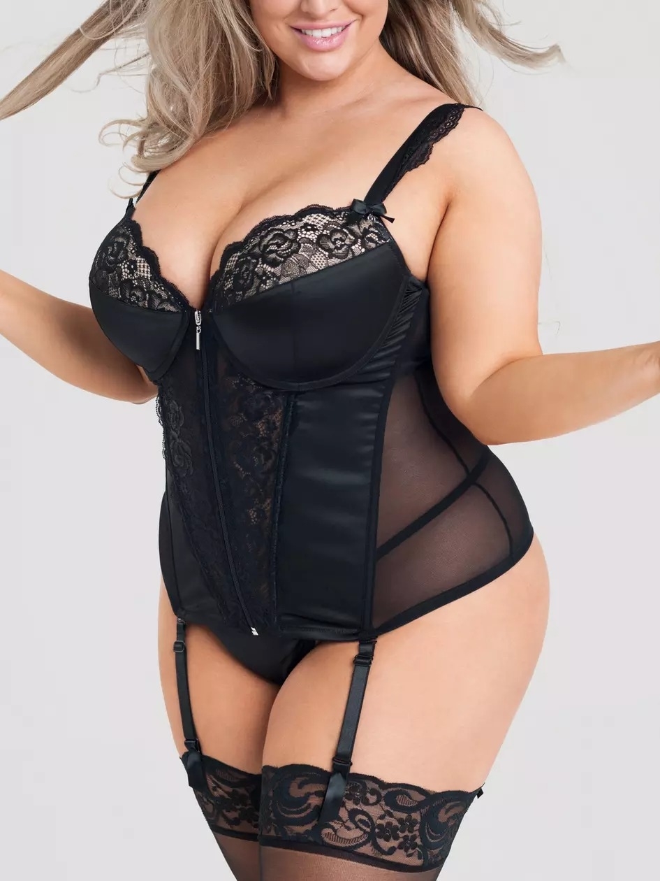 Model wearing black lace lingerie with satin panels and garters