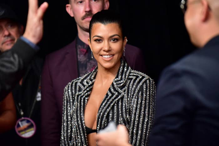 Kourtney Kardashian in a glittery jacket on a red carpet event