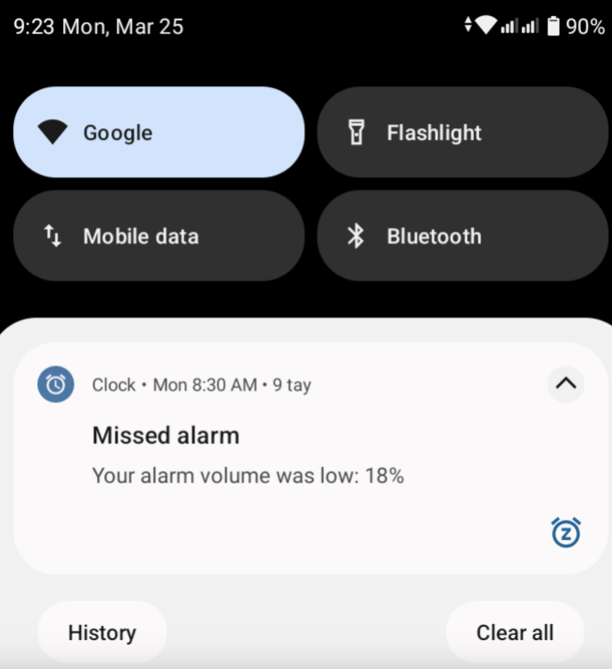 Phone screen showing notification &quot;Your alarm volume was low: 18%&quot; with icons for Google, flashlight, mobile data, and Bluetooth