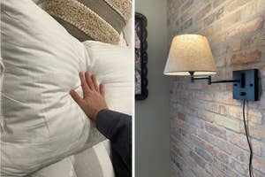 Hand testing the firmness of a pillow in a shopping display and a wall-mounted lamp beside a brick wall