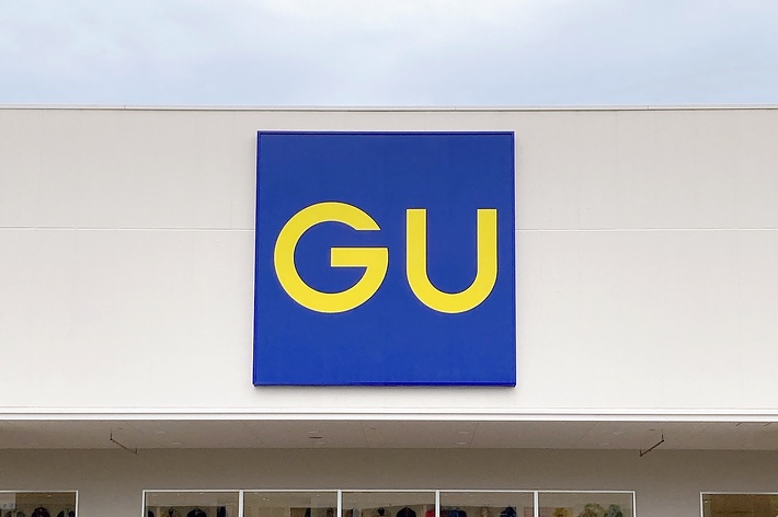 Storefront sign with large letters &ldquo;GU&rdquo; above the entrance of a clothing shop