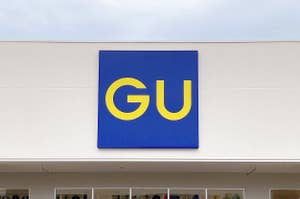 Storefront sign with large letters "GU" above the entrance of a clothing shop