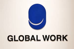 Logo of GLOBAL WORK on a wall with a blue circle and smiling design above the text