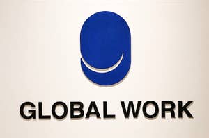Logo of GLOBAL WORK on a wall with a smile-like symbol above the text
