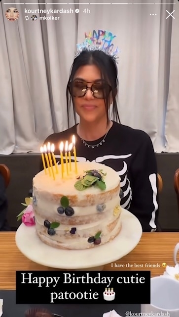 Kourtney Kardashian sitting in front of her cake