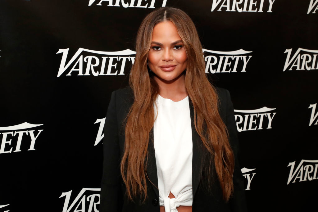 Chrissy Teigen in a black blazer and white top at a Variety event