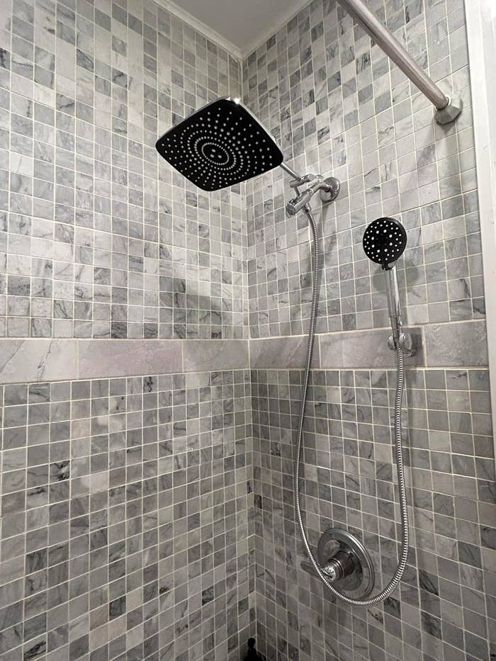 Showerhead with hose attached to tiled wall with adjustable rail for height