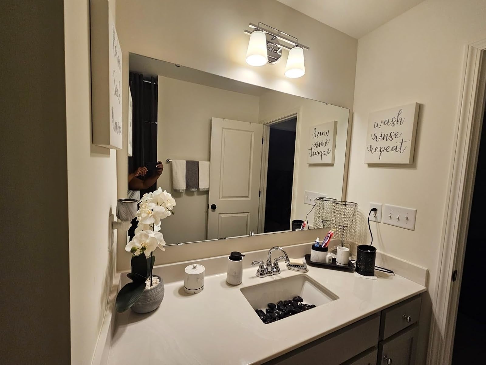Bathroom with sink, mirror, decorative texts, and assorted  idiosyncratic   attraction   items connected  the countertop