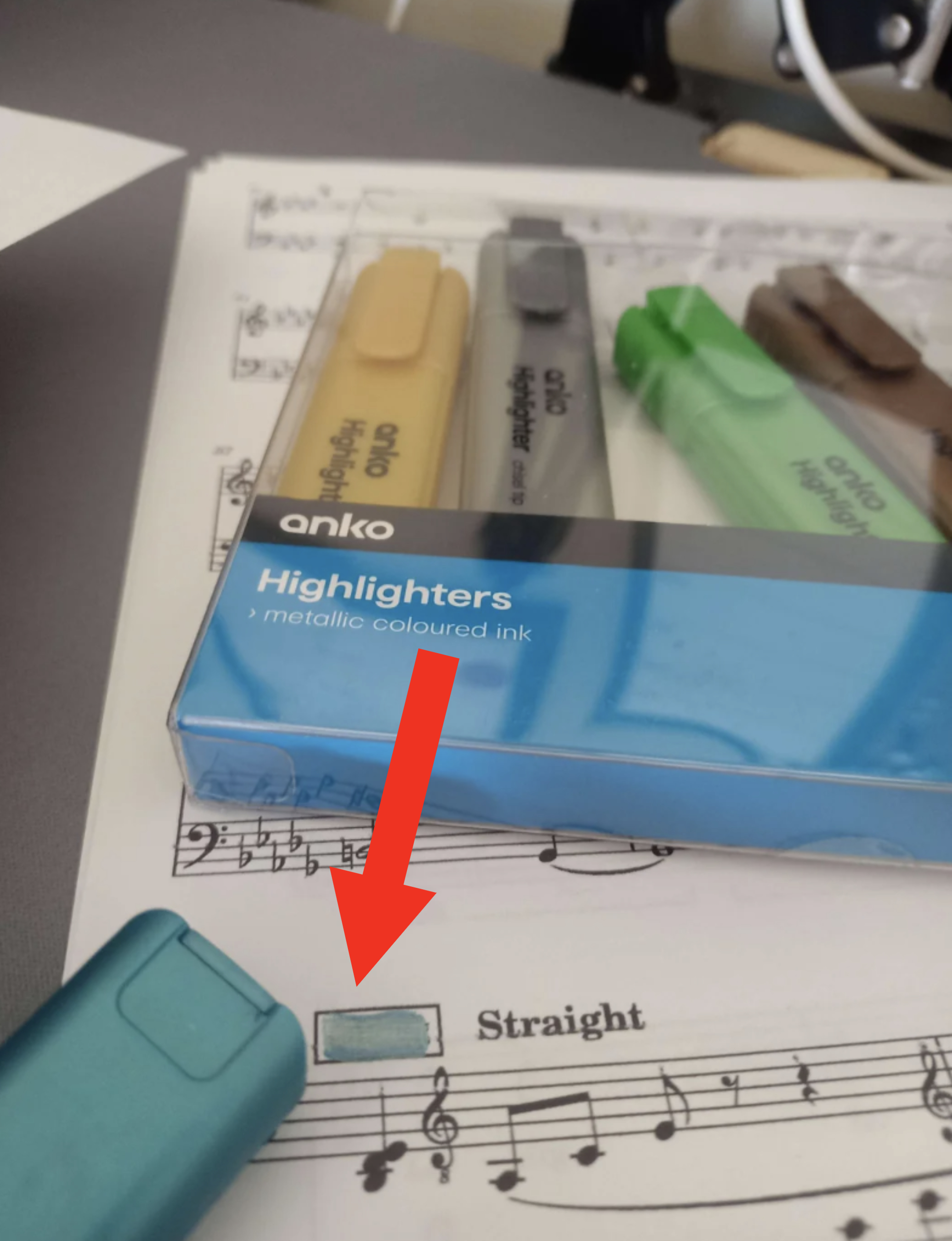 Four highlighters on sheet music, with a close-up of blue pack reading &#x27;metallic coloured ink&#x27;