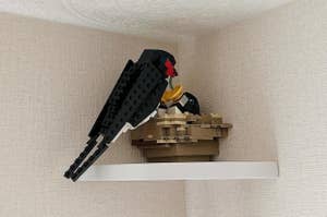 レゴ製の黒い鳥が小さな棚の上に展示されています。